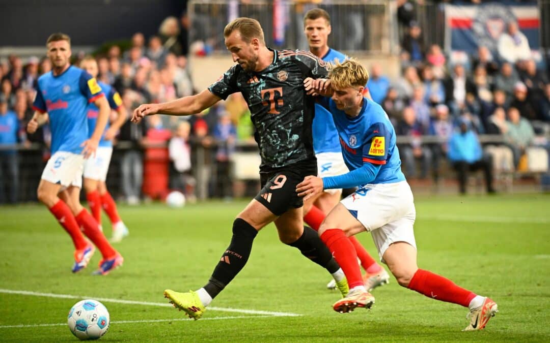 Bayerns Harry Kane (l-r) behauptet den Ball gegen Kiels Finn Porath.