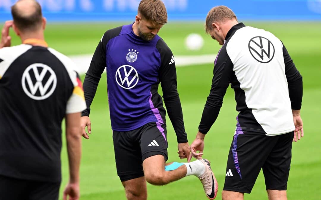 Niclas Füllkrug (M) nach seinem vergeblichen Härtetest beim Abschlusstraining im Gespräch mit Bundestrainer Julian Nagelsmann (r).