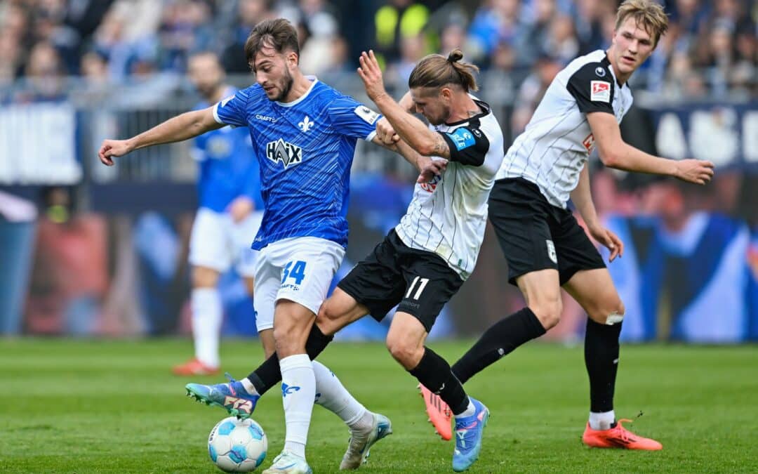 Darmstadts Killian Julian Corredor (l) und Ulms Dennis Chessa kämpfen um den Ball.