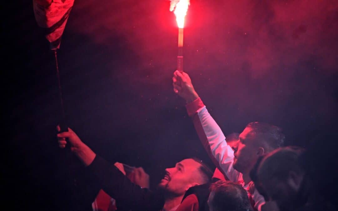 Lukas Podolski mit einer brennenden Pyro-Fackel in der Hand.