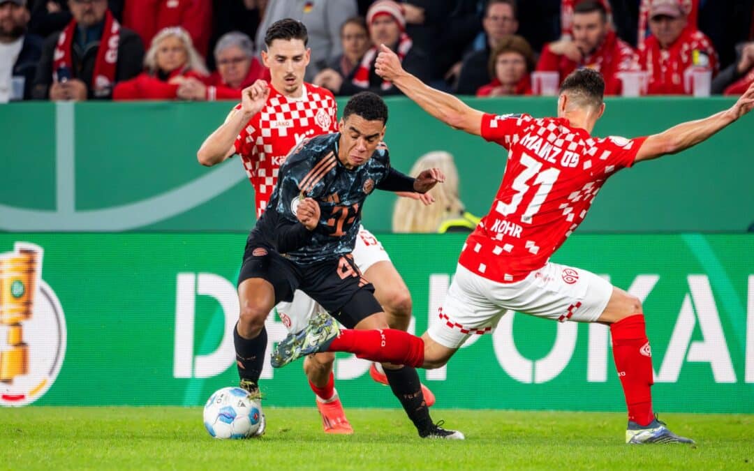 Jamal Musiala, hier beim Pokalspiel in Mainz, ist von den Gegenspielern kaum mit fairen Mitteln vom Ball zu trennen.