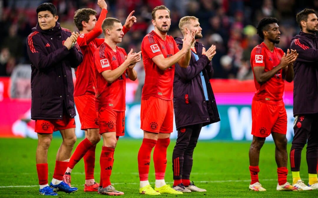 Die Bayern, in der Mitte der zweifache Torschütze Harry Kane, feiern das 3:0 gegen Union Berlin vor der Fankurve.