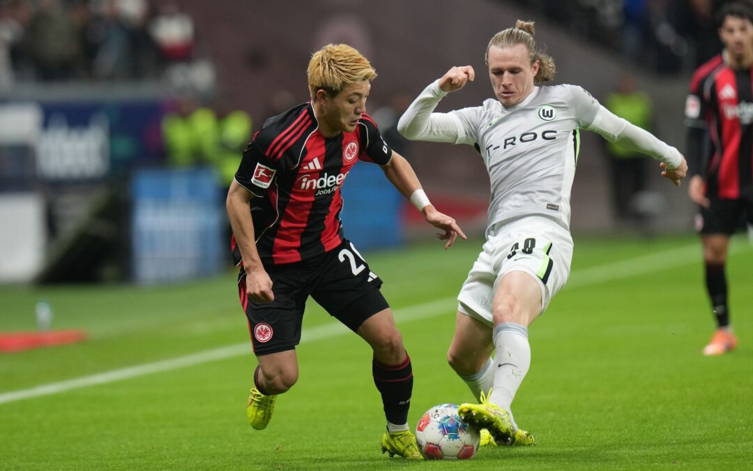 Lieferten sich eine umkämpfte Partie: Eintracht Frankfurt um Ritsu Doan (l) und der VfL Wolfsburg um Patrick Wimmer (r).
