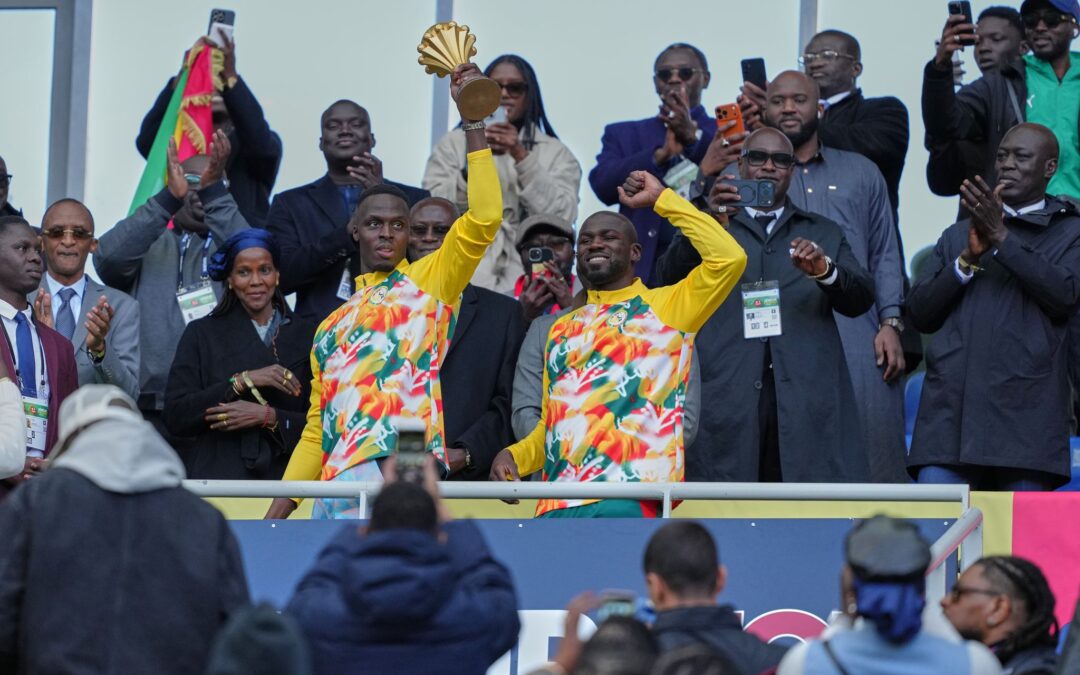 Senegalesische Spieler feiern mit der Afrika-Cup-Trophäe vor dem Spiel.